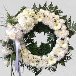 White floral wreath with ribbon and a small rose accent