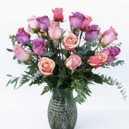 Pink and purple roses arranged in a glass vase