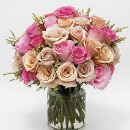 Bouquet of pink and peach roses in a clear glass vase