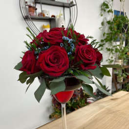 Red roses arranged in a wine glass vase