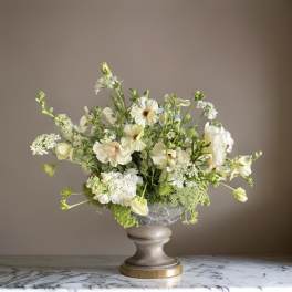 White floral arrangement in a gray pedestal vase