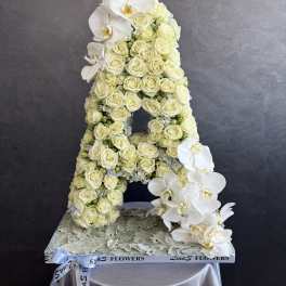 White rose and orchid floral arrangement shaped like the letter A