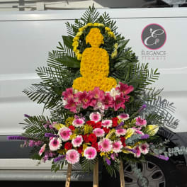 Standing floral tribute with yellow, pink, and red flowers on an easel