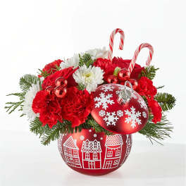 Christmas floral arrangement in a red ornament container with candy canes