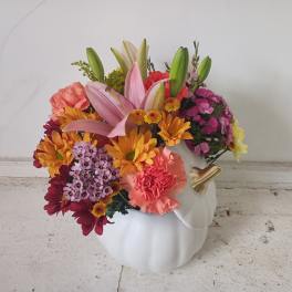 Colorful flower arrangement in a white pumpkin-shaped vase
