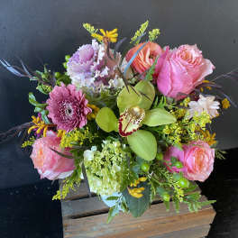 Pink roses and mixed blooms in a wooden box arrangement