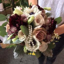 Handheld bouquet of blush and white flowers with pearl strands