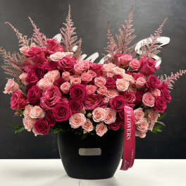 Large bouquet of pink and red roses in a black vase