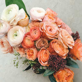 Peach and white ranunculus bouquet with dark berries