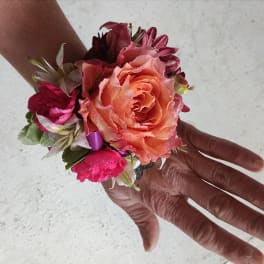 Small wrist corsage with peach and pink flowers