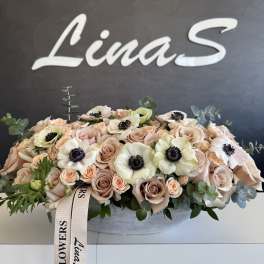 Blush rose arrangement with white anemones in a low oval container