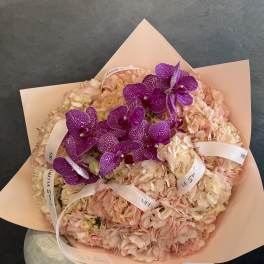 Pink hydrangea bouquet with purple orchids and ribbon accents