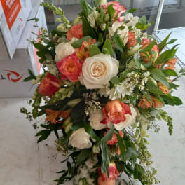 Large bouquet of pink, peach, and white roses with mixed blooms