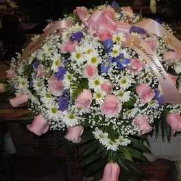 Large bouquet of pink roses, white daisies, and purple flowers with pink ribbons