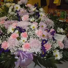 Large mixed bouquet of pink, white, and purple flowers with a lavender ribbon
