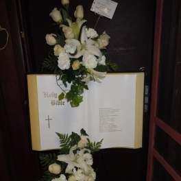 White floral spray on an open Bible display