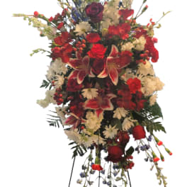 Tall standing floral spray with red, white, and burgundy blooms