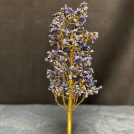 Decorative wire tree with blue stone chips on a matching stone base