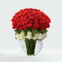 Large bouquet of red roses with white flowers in a clear glass vase