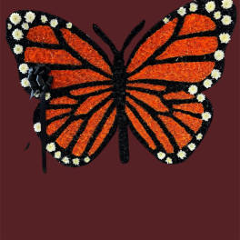 Butterfly-shaped floral tribute with orange and black petals and white accents