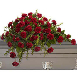 Red carnation spray on a gray casket
