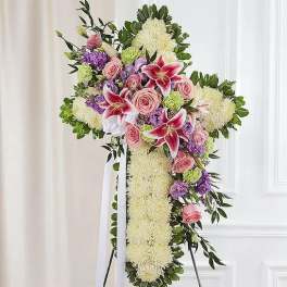 Standing floral cross with pink roses and lilies on an easel