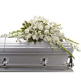 White floral casket spray on a silver casket