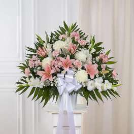 Pink and white floral spray with a white ribbon bow