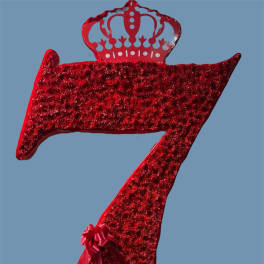 Red glitter crown-shaped decorative number seven with a ribbon bow