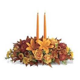 Autumn floral centerpiece with two orange taper candles