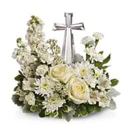 White floral arrangement with a silver cross centerpiece