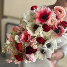 Handheld bouquet of pink, red, and white flowers