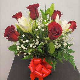 Bouquet of red roses and white lilies with a red ribbon bow