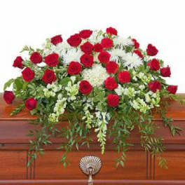 Red roses and white flowers arranged on a casket