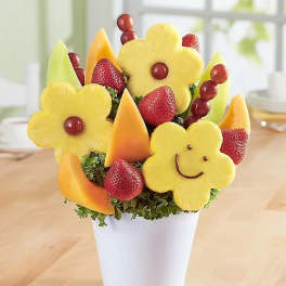 Fruit bouquet in a white cup with carved pineapple flowers and strawberries