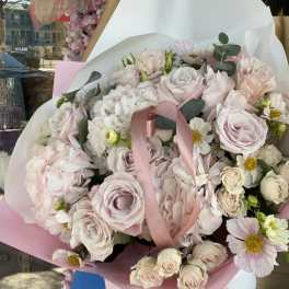 Bouquet of pale pink roses and white flowers wrapped in pink paper