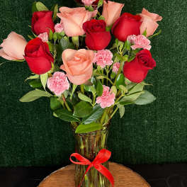 Red and blush roses in a glass vase with a heart balloon