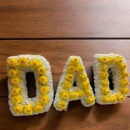 Yellow and white floral letters spelling DAD