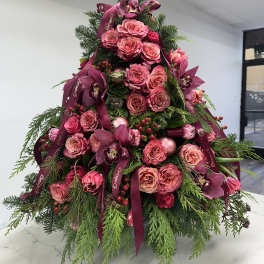 Pink roses and orchids arranged in a tree shape with burgundy ribbons