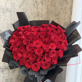 Large bouquet of red roses wrapped in black paper
