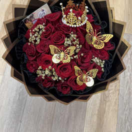 Bouquet of red roses with gold butterfly decorations and a jeweled crown