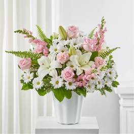 Pink roses and white lilies in a white vase