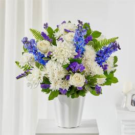 White and purple flower arrangement in a white vase