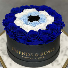 Round box of blue, white, and light blue roses with a black center rose
