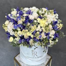 Large bouquet of white and blue flowers in a white hat box