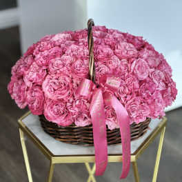 Basket of pink roses with a pink ribbon bow