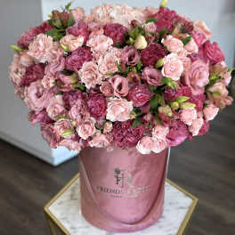 Large pink bouquet of roses and carnations in a pink hatbox