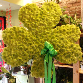 Large green floral teddy bear with a ribbon bow