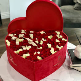 Heart-shaped red box filled with red and white roses