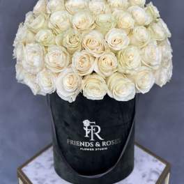 Cream-white roses arranged in a black hatbox